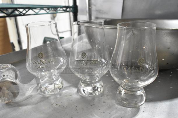 Lot of items: three Casa Noble tequila glasses, metal colander, metal baking pan. Glasses in good condition, logos visible.