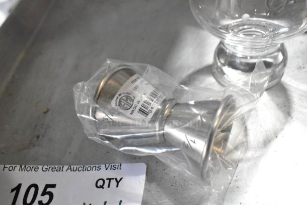 Lot of various items including a wrapped metal jigger, clear glass, and tray. Tags indicate "Made in India." Item 105.