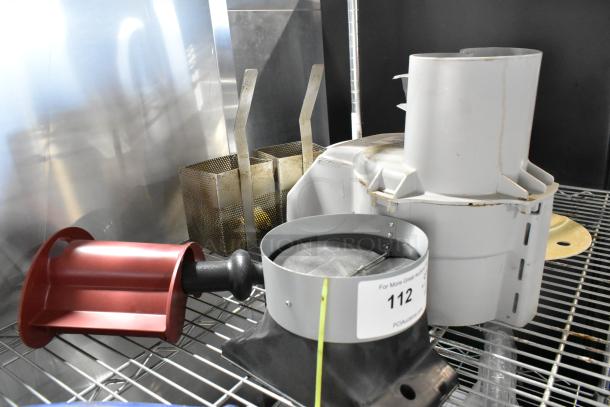 Auction lot including a food processor feed head, Dormont gas hoses, and ceramic plates. Mixed condition with visible wear.