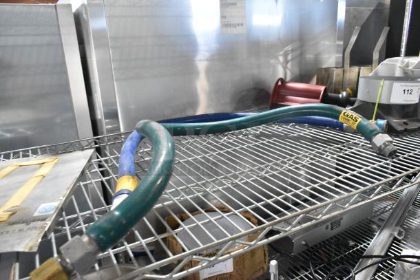 Tier lot of items on wire shelf, featuring Dormont gas hoses, food processor head, and ceramic plates, good condition.