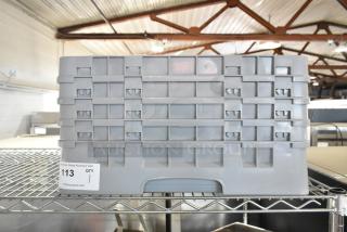 Gray poly dish rack on metal shelf, featuring a durable rectangular design with multiple slots. Auction tag reads “113.”