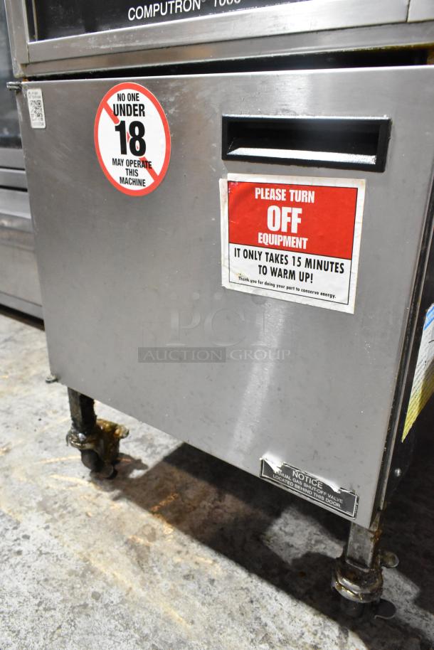 Henny Penny 600 stainless steel pressure fryer with 80,000 BTU, natural gas powered, on commercial casters. Warning labels visible.