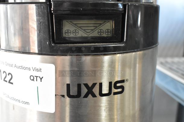 Fetco Luxus L4S-15 stainless steel beverage dispenser with digital display and visible brand label. Good condition.