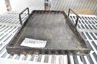 Rustic metal tray with raised edges and dual handles. Visible wear and rust give it a vintage look. Auction tag 123 attached.