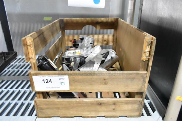 Wooden crate containing seven assorted price guns, some with attached labels or rolls of labels, in used condition.