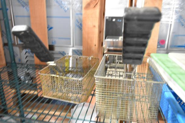 Two-tier lot with poly bins, cutting boards, and fry baskets on industrial shelving. Handles on baskets visible. Moderate wear.