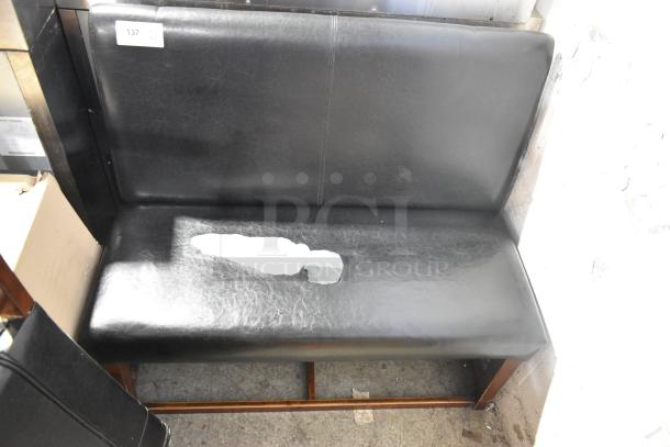 Two black single-sided booth seats with leather-like material, visible wear and tear, numbered tag "137."