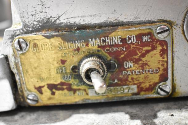 Globe 660 Metal Commercial Meat Slicer with Blade Sharpener, showing worn label indicating model and patented switch.