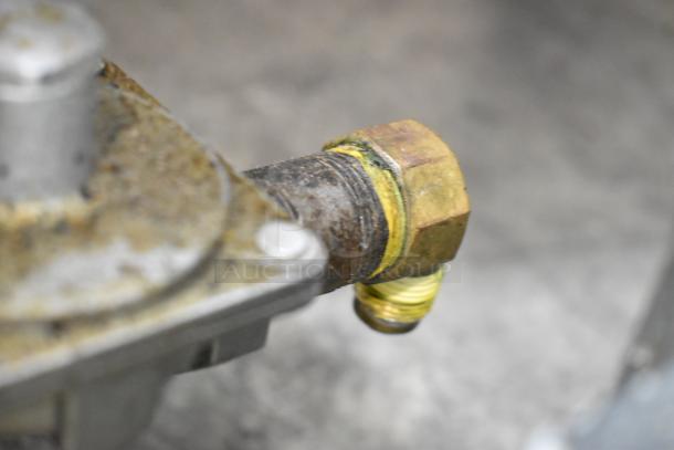 Close-up of a metal fitting on a 2022 Rocket Cooking Stainless Steel 2 Burner Range. Shows a natural gas connection.