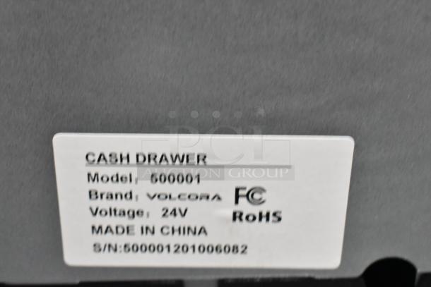 Label on metal cash drawer, Model: 500001, Brand: Volcora, Voltage: 24V, Made in China, with serial number.
