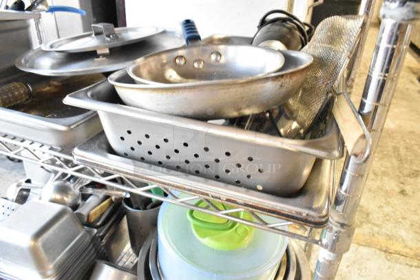 Three-tier lot of various kitchen items including wooden pizza peels, stainless steel drop-in bins, skillets, and baking pans.