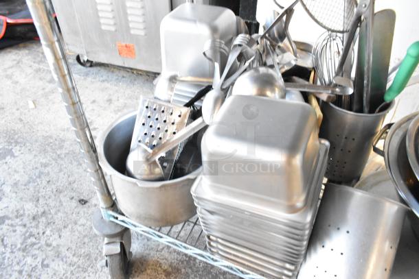 Three-tier lot with wooden pizza peels, stainless steel bins, skillets, and round baking pans on a cart, various conditions.