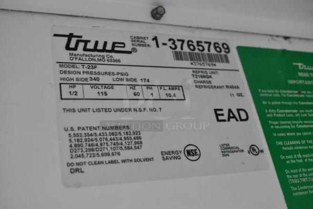 Label on True T-23F freezer showing model details, voltage 115V, phase 1, refrigerant R404A, and NSF certification.