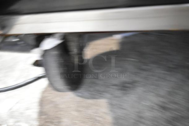 Blurry image of the Atosa MSF8008 prep table's caster wheel. Stainless steel, commercial-grade quality.