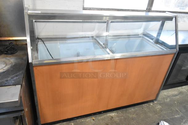 Metal commercial ice cream dipping cabinet with ice cream tub collars, 115 volts, 1 phase, wood paneling, glass top.