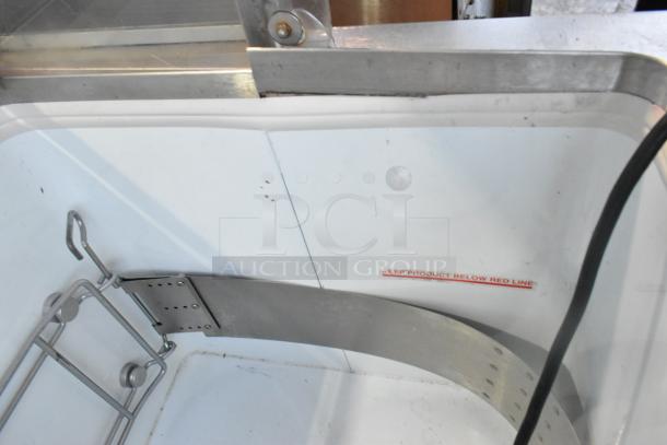 Metal commercial ice cream dipping cabinet featuring ice cream tub collars, visible label, 115 volts, 1 phase.