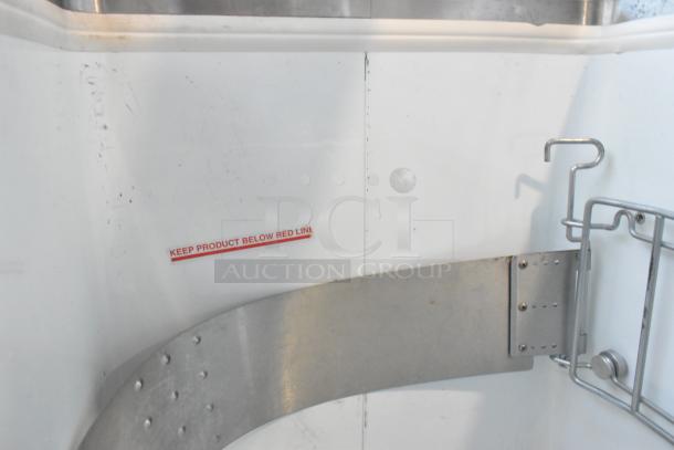 Metal commercial ice cream dipping cabinet showing interior with ice cream tub collars and "Keep Product Below Red Line" marking.