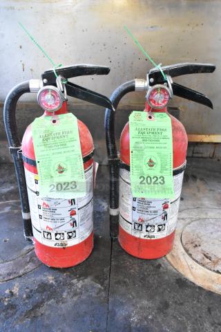 Two Kidde fire extinguishers, red, tagged "2023," labeled by Allstate Fire Equipment, not for shipment. Buyer pickup required.