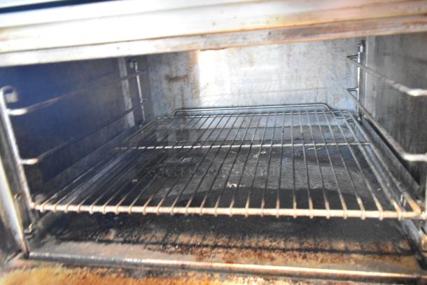 Jade Range JTRH-2FHT-36 stainless steel gas oven interior, showing wire racks, used condition with visible wear.