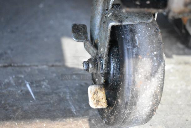 Close-up of a caster wheel on a Jade Range JTRH-2FHT-36, showing wear and dirt. Suitable for commercial kitchen use.