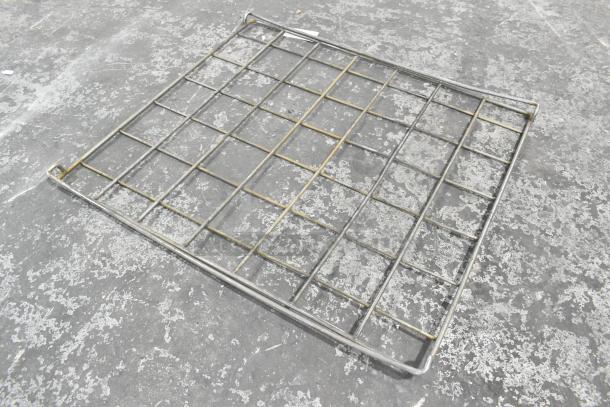 Metal rack with grid design, in used condition, showing some wear. Ideal for storage or display purposes.