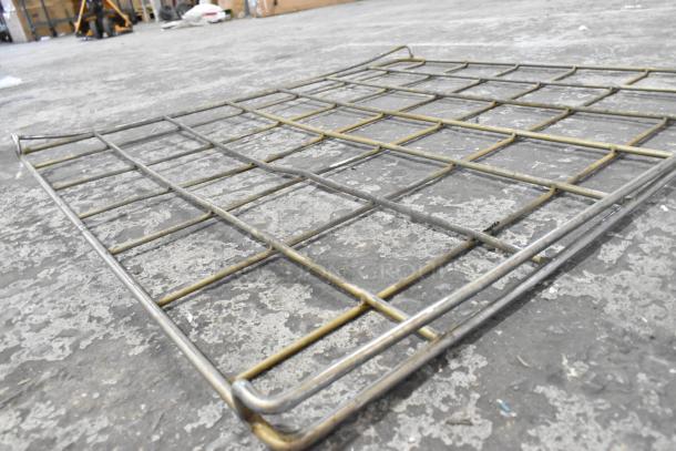 Metal rack with grid pattern, slight wear, suitable for storage, sturdy construction, dimensions approximately 3x2 feet.