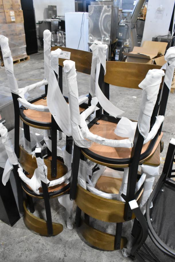 8 new Lancaster Table & Seating black metal chairs with wooden backrests and seats, packaged for shipping.