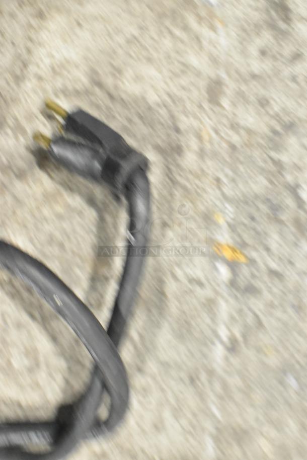 Blurry image of a power plug, possibly part of the Stoelting SF121-38I2 soft serve ice cream machine.