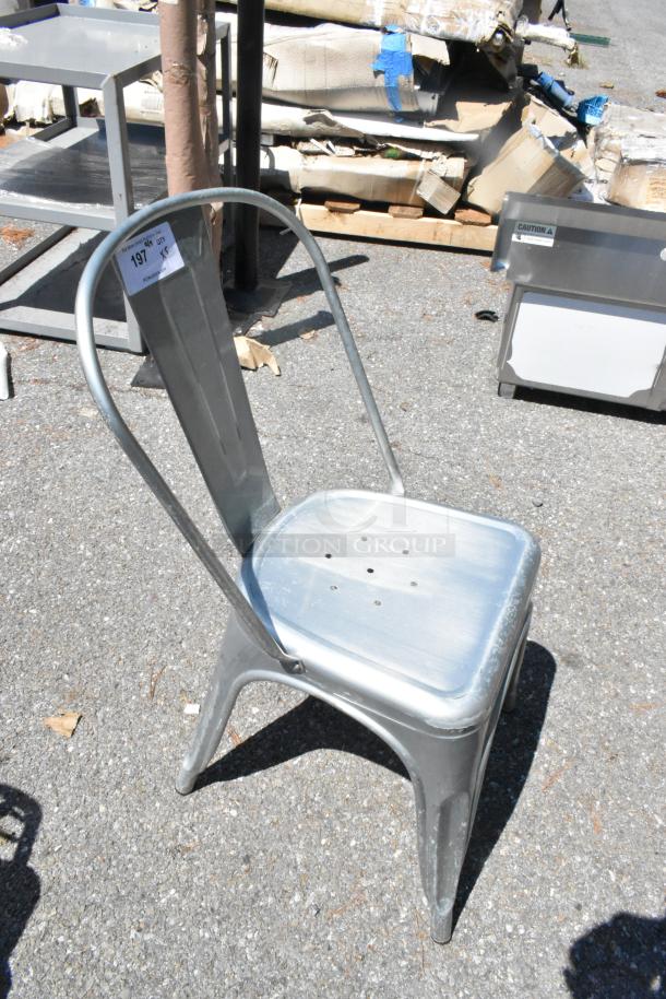 Metal Tolix style dining chair, silver finish, industrial design, stackable, gently used, auction label reads "197 QTY 5".
