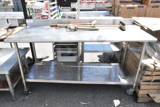 Commercial stainless steel table with two grill brushes, can opener, metal under shelf, and casters. Great condition.