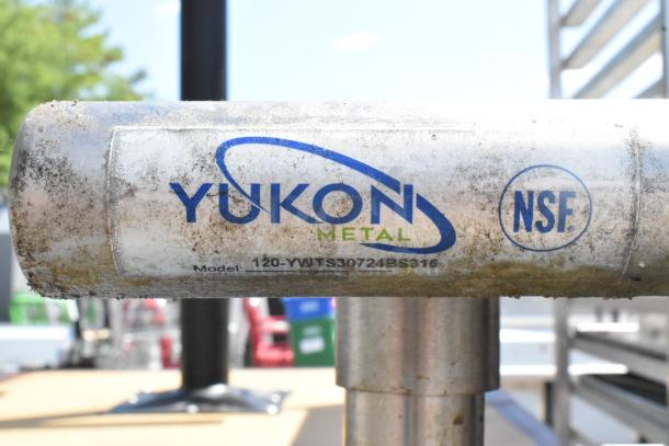 Stainless steel table by Yukon Metal, model 120-YWTS30724BS316, with NSF marking; includes grill brushes, can opener, metal under shelf, on commercial casters.