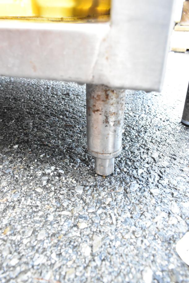 John Boos EUBGRS-24-3 stainless steel drain board leg, showing minor surface rust on textured ground.