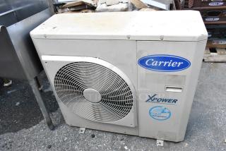 Carrier Xpower Air Conditioning Inverter, visible fan, moderate wear, labels for brand and model.