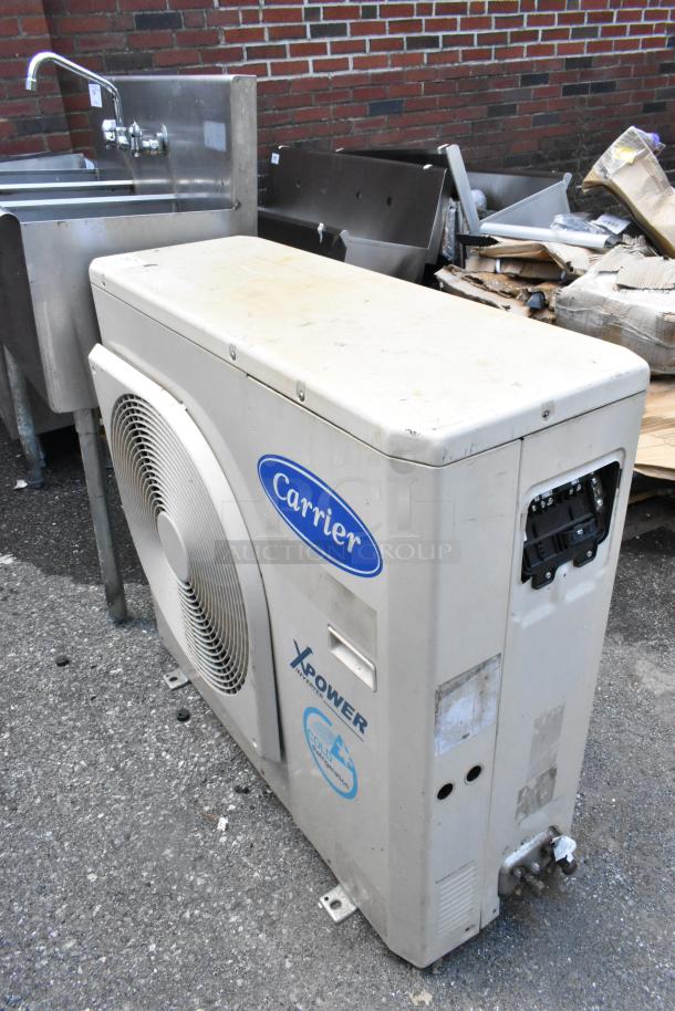 Carrier Xpower Air Conditioning Inverter in fair condition, featuring brand logo, model markings, and visible wear on the casing.