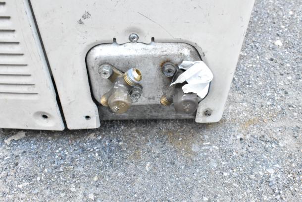 Carrier Xpower Air Conditioning Inverter, showing its connection ports on a metallic panel. Slight wear visible.