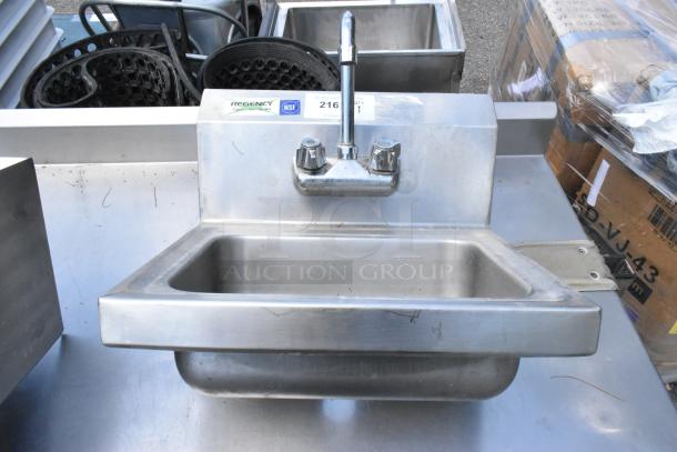Regency stainless steel wall mount sink, single bay with faucet and handles, NSF certified, showing light wear.