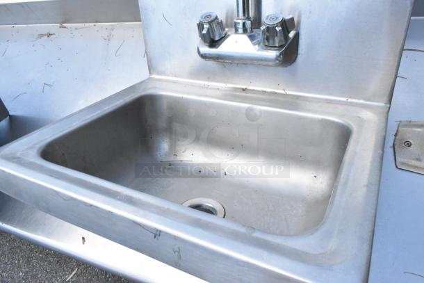 Regency stainless steel wall mount sink with faucet and handles, single bay, used condition, minor surface wear visible.