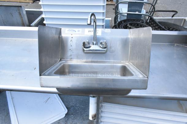 Yukon stainless steel single bay wall mount sink with side splash guards, faucet, and handles, in used condition.