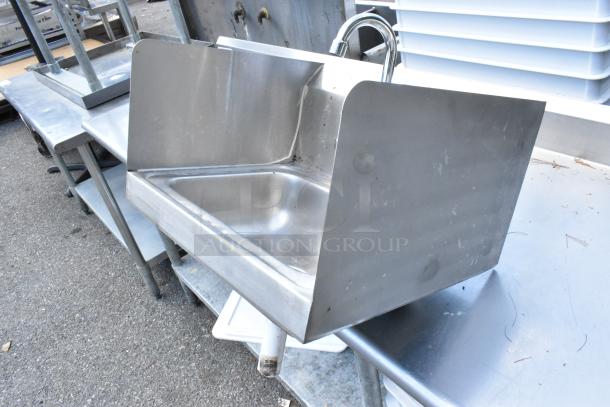Yukon stainless steel wall mount sink with side splash guards, faucet, and handles. Shows minor wear and sturdy construction.