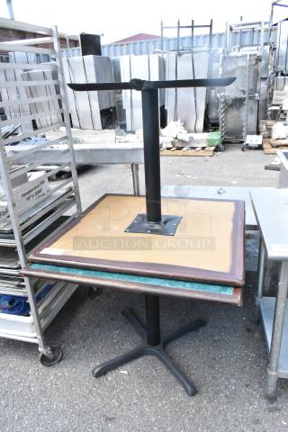 Two tables with green and wood pattern tabletops, black metal bases; wear visible. Auction includes two tables.