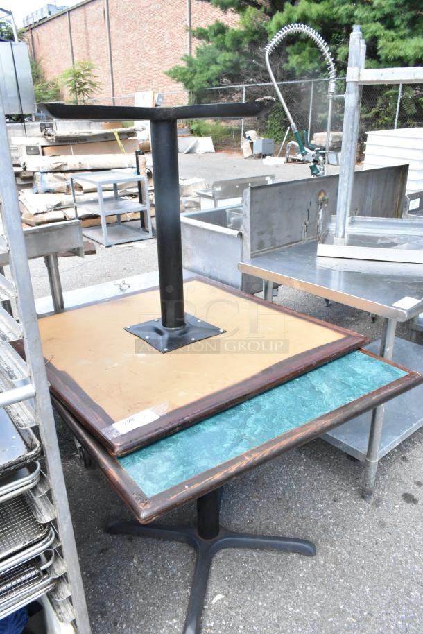Two tables with green and wood-patterned tabletops on black metal bases, fair condition. Auction tag visible.