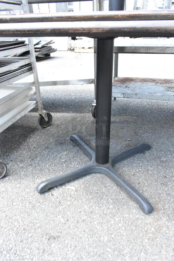 Two tables with green and wood pattern tabletops, black metal bases, sturdy construction, suitable for indoor use.