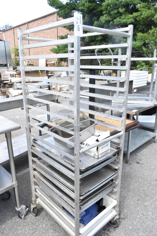 Metal commercial pan transport rack on casters, including 12 metal baking pans. Used condition, with visible wear and labels.