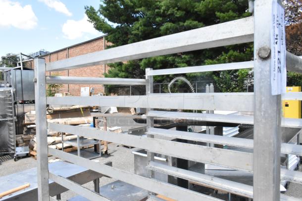 Metal commercial pan transport rack with commercial casters, includes 12 metal baking pans, visible condition used.
