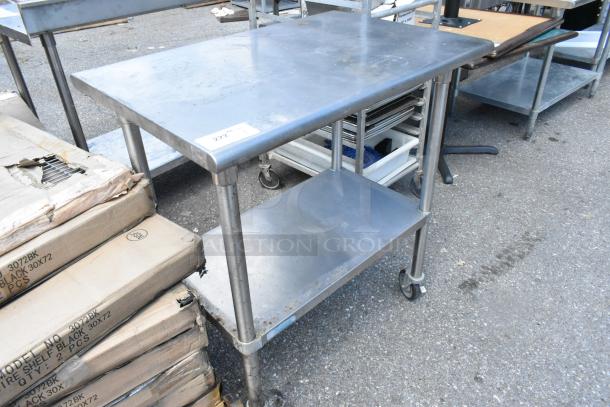 Stainless steel table with metal under shelf, commercial casters, in good condition. Label marked "222."