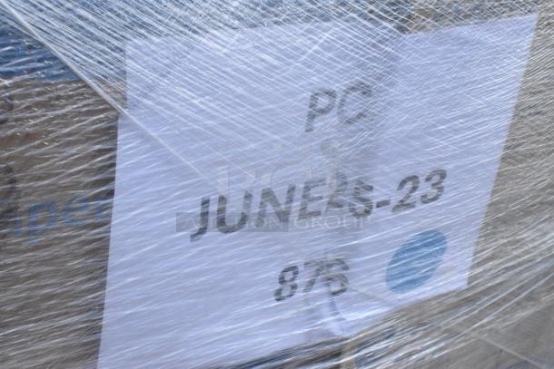 Plastic-wrapped pallet with a label reading "PC JUNE25-23 876," containing a mix of paper towel rolls, lids, and cups.