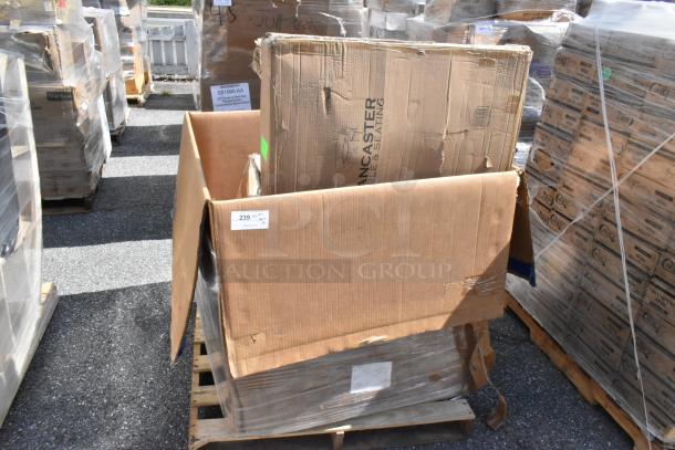Cardboard box labeled "Lancaster Table & Seating" on a pallet, showing signs of damage and wrapped in plastic.