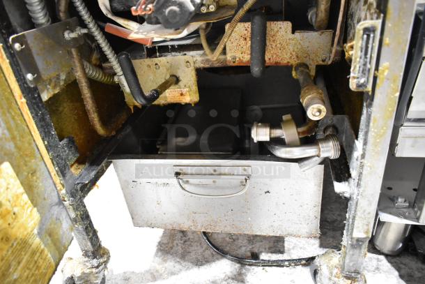 Henny Penny 600 stainless steel pressure fryer, natural gas powered, on casters. Interior shows signs of wear and rust.