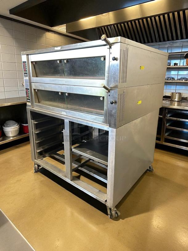 Commercial double-deck oven on wheeled stand with stainless steel construction, digital controls, and visible thermometers.