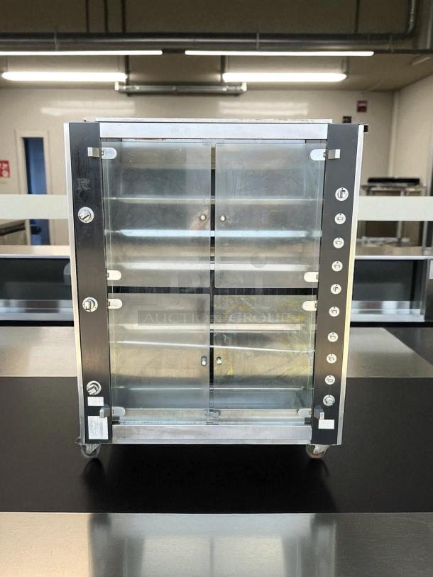 Commercial kitchen display case 131, stainless steel frame, transparent sliding doors, lockable, on wheels, excellent condition.